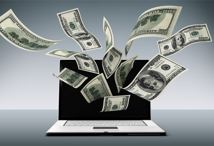 Foto banconote in dollari che volano fuori dallo schermo del laptop