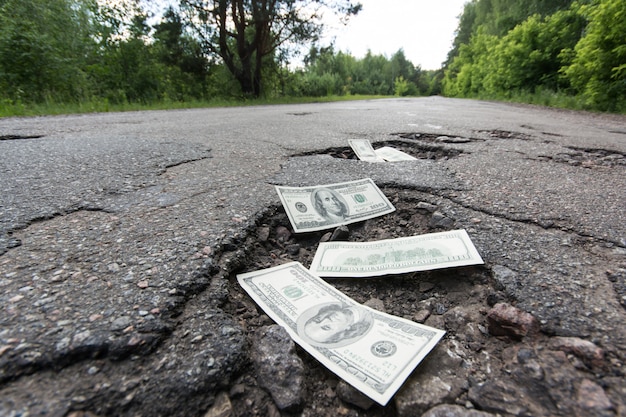 Banconote in dollari nelle buche sulla strada