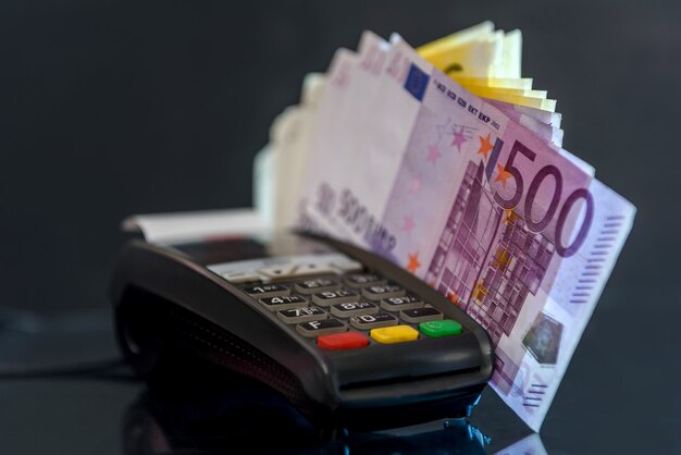 Banconote in euro con terminale sulla tavola nera