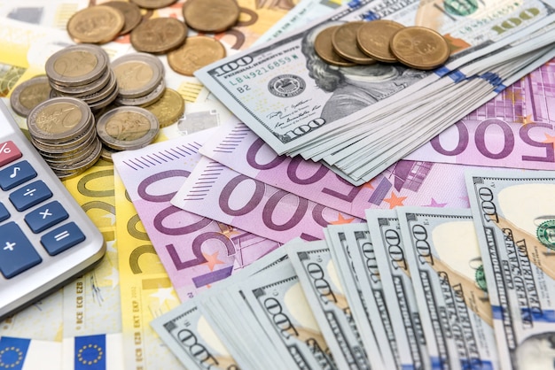 Banconote in euro e dollari come sfondo per monete e calcolatrice