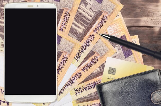 Banconote in rubli bielorussi e smartphone con borsa e carta di credito