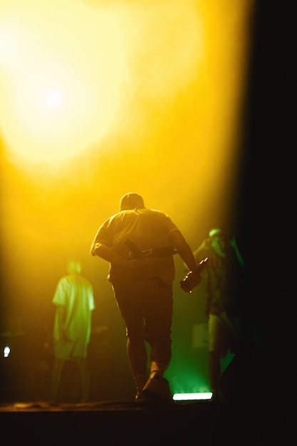 Banda musicale sul palco di luci di sottofondo in concerto o festival un cantante che balla con il microfono