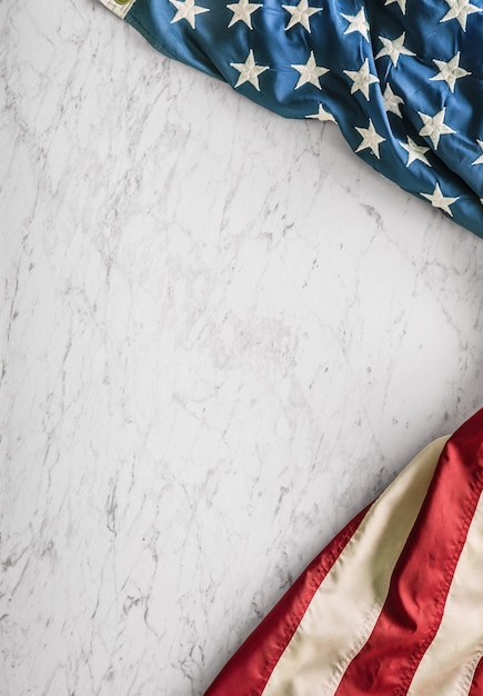 Bandiera americana del primo piano su fondo di marmo bianco.