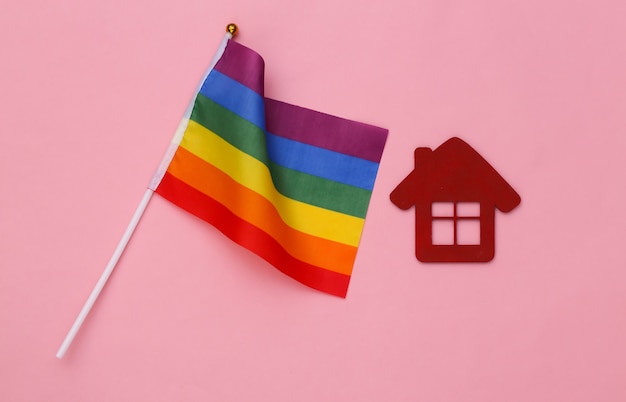 Bandiera arcobaleno LGBT e casa su sfondo rosa. Tolleranza, libertà