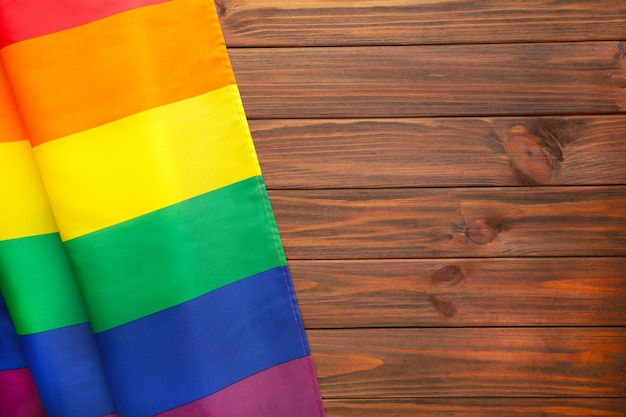 Bandiera arcobaleno LGBT su fondo di legno marrone con spazio di copia