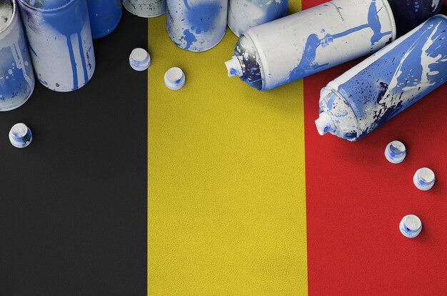 Bandiera belga e poche bombolette spray aerosol utilizzate per la pittura di graffiti Concetto di cultura dell'arte di strada