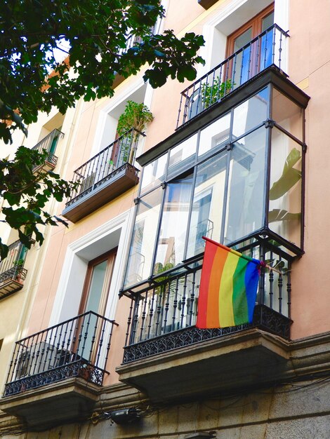 Bandiera colorata della comunità LGBT appesa sul classico balcone vintage nel quartiere gay di Madrid, Spagna