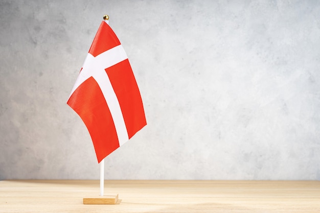 Bandiera da tavolo della Danimarca sulla parete strutturata bianca. Copia spazio per testo, disegni o disegni