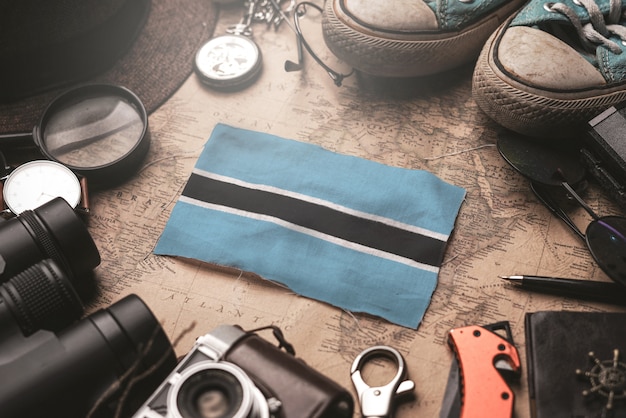 Bandiera del Botswana tra gli accessori del viaggiatore sulla vecchia mappa vintage. Concetto di destinazione turistica.