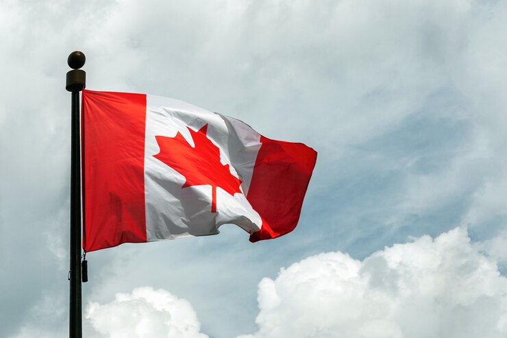 Foto bandiera del canada sul pennone che galleggia nel cielo