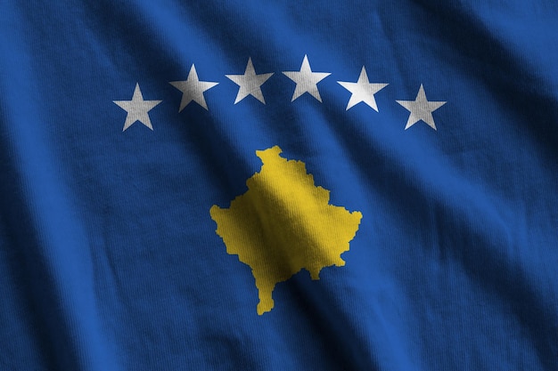 Bandiera del Kosovo con grandi pieghe che ondeggiano da vicino sotto la luce dello studio all'interno I simboli e i colori ufficiali nel banner