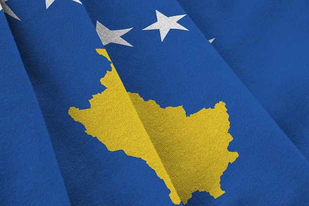 Bandiera del Kosovo con grandi pieghe che ondeggiano da vicino sotto la luce dello studio all'interno I simboli e i colori ufficiali nel banner