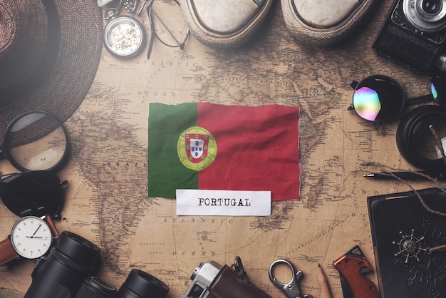 Bandiera del Portogallo tra gli accessori del viaggiatore sulla vecchia mappa vintage. Colpo ambientale