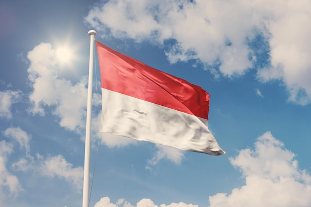 Bandiera dell'Indonesia, simbolo nazionale che sventola contro nuvoloso, cielo blu, giornata di sole