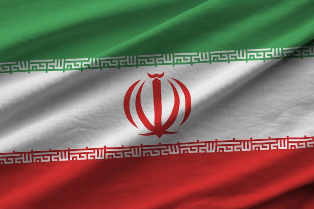 Bandiera dell'Iran con grandi pieghe che ondeggiano da vicino sotto la luce dello studio all'interno I simboli e i colori ufficiali nel banner