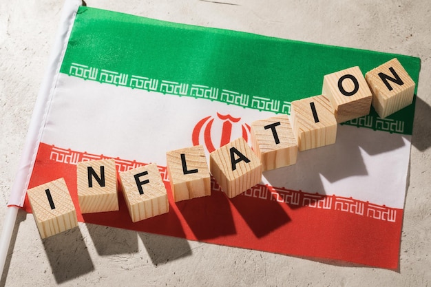 Bandiera dell'Iran e cubi di legno con testo un concetto sul tema dell'inflazione nel paese