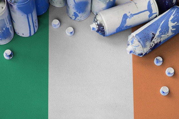 Bandiera dell'Irlanda e poche bombolette spray aerosol utilizzate per la pittura di graffiti Concetto di cultura dell'arte di strada