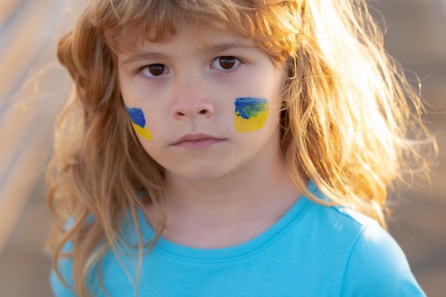 Bandiera dell'Ucraina sulla guancia dei bambini nessuna guerra fermare la guerra aggressione russa piccolo patriota ucraino