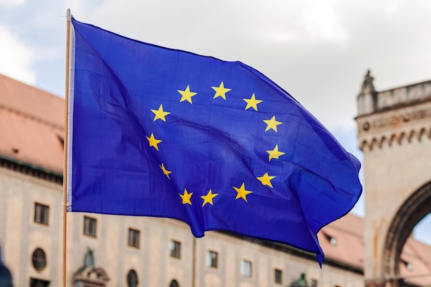 Bandiera dell'UE Bandiera dell'Unione europea che soffia sullo sfondo del cielo di architettura