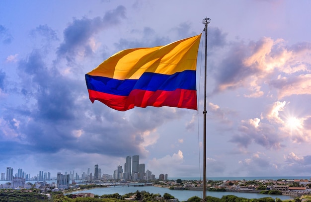 Bandiera della Colombia che sventola davanti allo skyline moderno di Cartagena vicino al centro storico e alla zona degli hotel