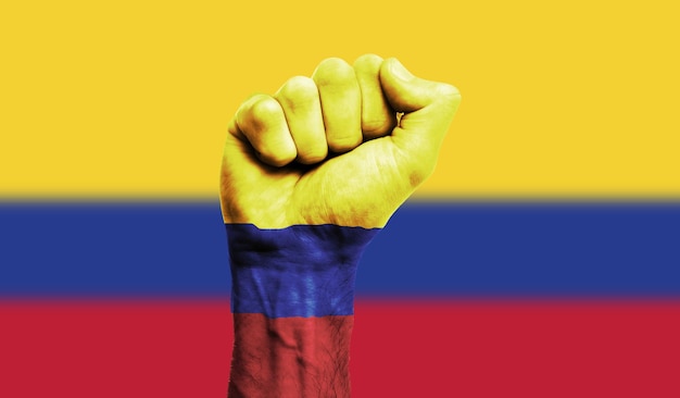 Bandiera della Colombia dipinta su un concetto di protesta della forza del pugno chiuso