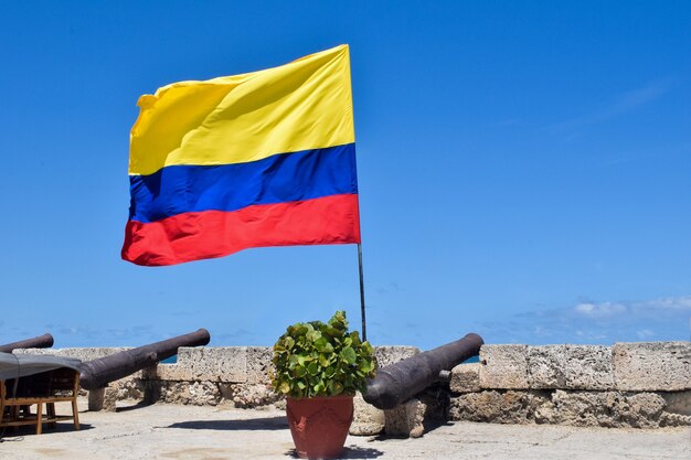 Bandiera della Colombia svolazzanti e cannonate sulle mura della città nel centro storico di Cartagena.