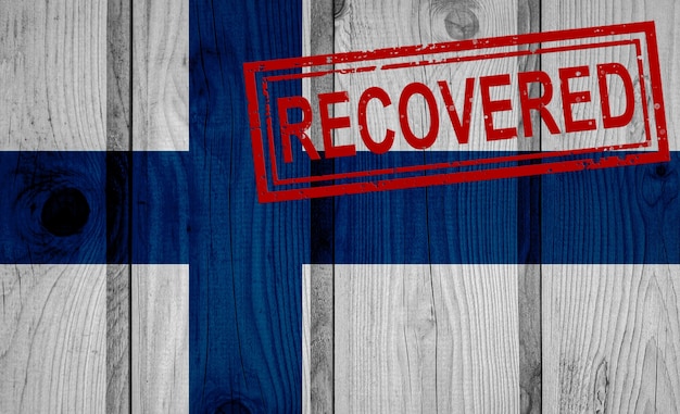Bandiera della Finlandia sopravvissuta o guarita dalle infezioni dell'epidemia di virus corona o coronavirus. Bandiera grunge con timbro Recuperato