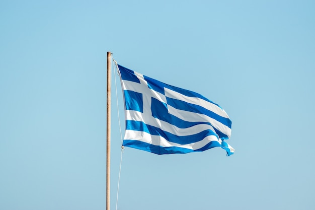 Bandiera della Grecia sul pennone contro il cielo blu