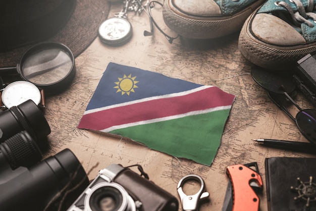 Bandiera della Namibia tra gli accessori del viaggiatore sulla vecchia mappa d'annata. Concetto di destinazione turistica.