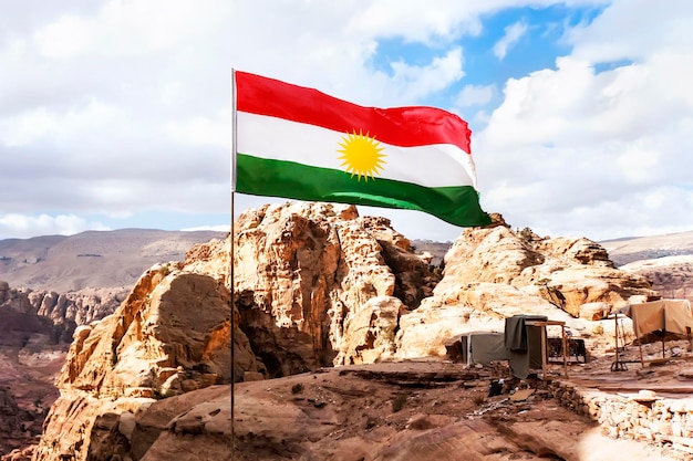 Bandiera della non riconosciuta Repubblica del Kurdistan nelle montagne contro il cielo e la natura del Medio Oriente