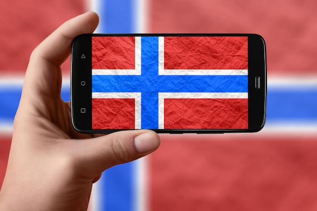 Bandiera della Norvegia sullo schermo del telefono Smartphone in mano fotografando la bandiera