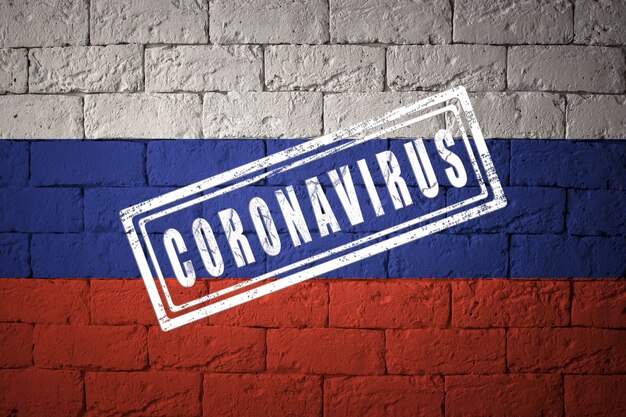 Bandiera della Russia con proporzioni originali. timbrato di Coronavirus. struttura del muro di mattoni. Concetto di virus corona. Sull'orlo di una pandemia di COVID-19 o 2019-nCoV.