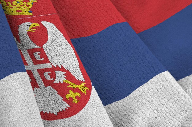 Bandiera della Serbia con grandi pieghe che ondeggiano da vicino sotto la luce dello studio all'interno I simboli e i colori ufficiali nel banner