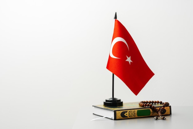 Bandiera della Turchia sul Corano con perline su sfondo bianco