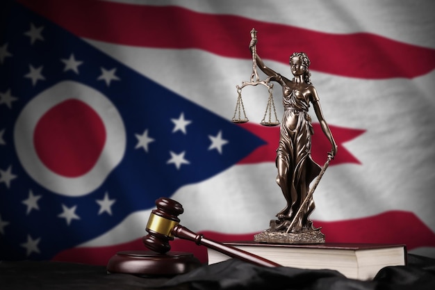 Bandiera dello stato americano dell'Ohio con la statua della costituzione della giustizia della signora e martello del giudice sul concetto di panneggio nero