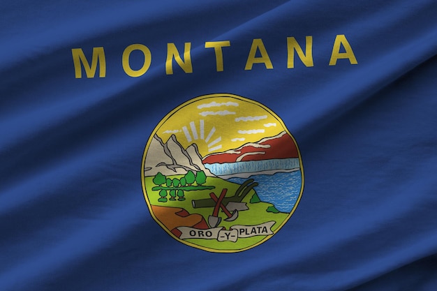 Bandiera dello stato degli Stati Uniti del Montana con grandi pieghe che ondeggiano da vicino sotto la luce dello studio all'interno I simboli e i colori ufficiali nel banner