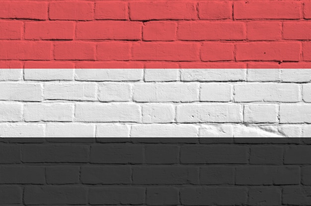 Bandiera dello Yemen nei colori della vernice sul vecchio muro di mattoni