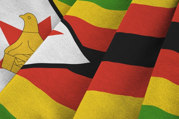 Bandiera dello Zimbabwe con grandi pieghe che ondeggiano da vicino sotto la luce dello studio all'interno I simboli e i colori ufficiali nel banner