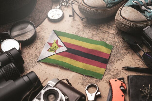 Bandiera dello Zimbabwe tra gli accessori del viaggiatore sulla vecchia mappa vintage. Concetto di destinazione turistica.