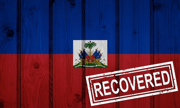 Bandiera di Haiti sopravvissuta o guarita dalle infezioni dell'epidemia di virus corona o coronavirus. Bandiera grunge con timbro Recuperato