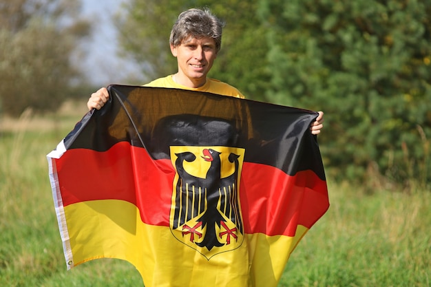 Bandiera di seta della Germania nelle mani dell'uomo
