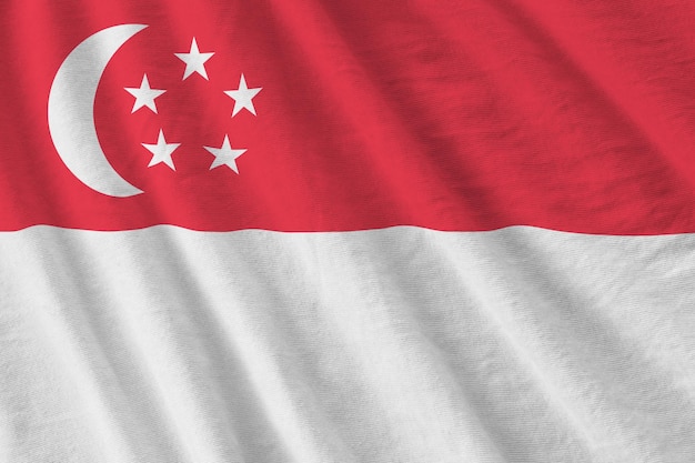Bandiera di Singapore con grandi pieghe che ondeggiano da vicino sotto la luce dello studio all'interno I simboli e i colori ufficiali nel banner