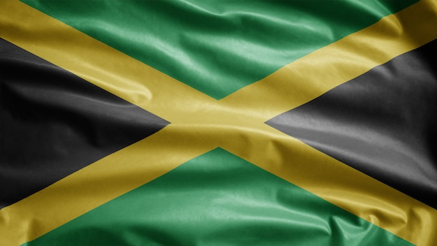Bandiera giamaicana che fluttua nel vento. Bandiera Giamaica che soffia, seta morbida e liscia.