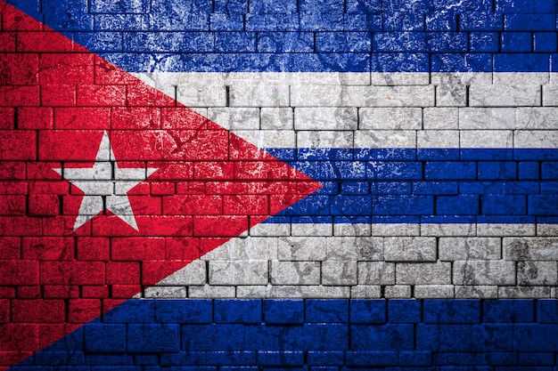 Bandiera nazionale di Cuba su sfondo di muro di mattoni.