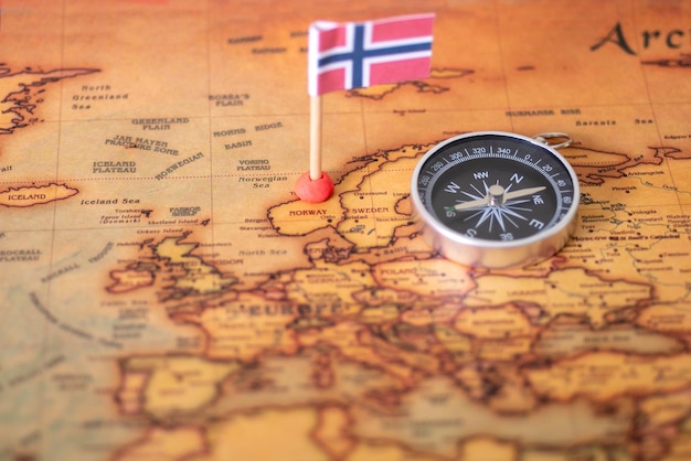 Bandiera norvegese e bussola sulla mappa del mondo