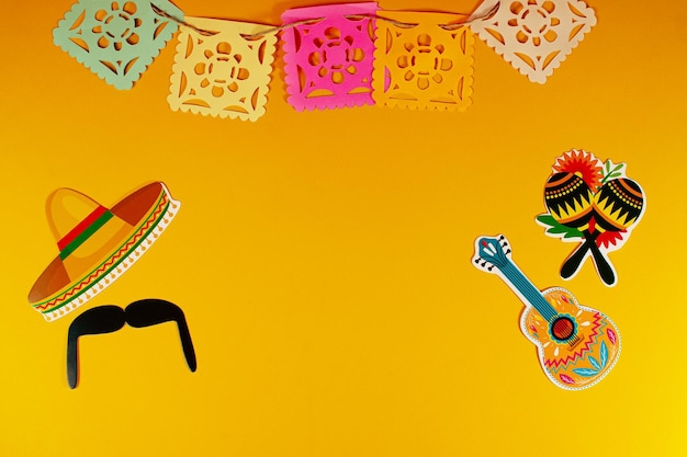 Bandiera tradizionale di carta, cappello messicano e decorazione Happy Cinco de Mayo vista dall'alto sullo sfondo
