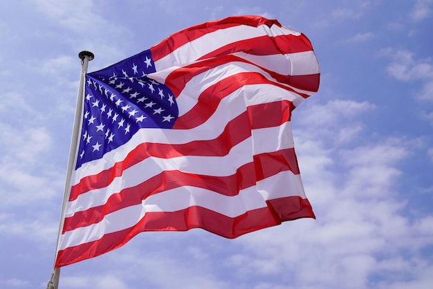 Bandiera Usa americana che galleggia in stuoia con vento sul cielo blu della nuvola