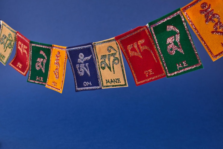 Foto bandiere buddiste tibetane su sfondo blu testo sulle bandiere om mani padme hum che significa che il gioiello è