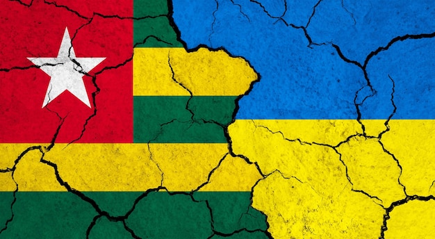 Bandiere del Togo e dell'Ucraina sul concetto di relazione politica di superficie incrinata