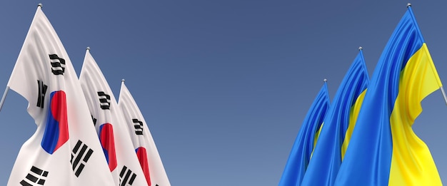 Bandiere della Corea del Sud e dell'Ucraina sui pennoni sui lati Bandiere su sfondo blu Posto per il testo Ucraina libera indipendente Tre bandiera della Corea del Sud Illustrazione 3D del Commonwealth